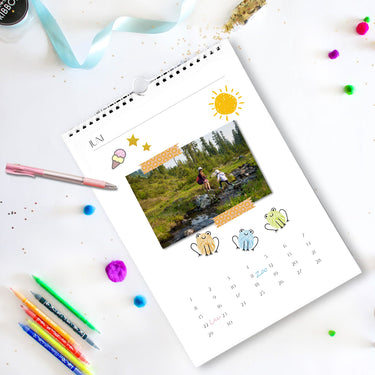 Personalisierter Kalender mit Familienfoto, bunten Frosch-Illustrationen und handgeschriebenen Terminen für Juni.