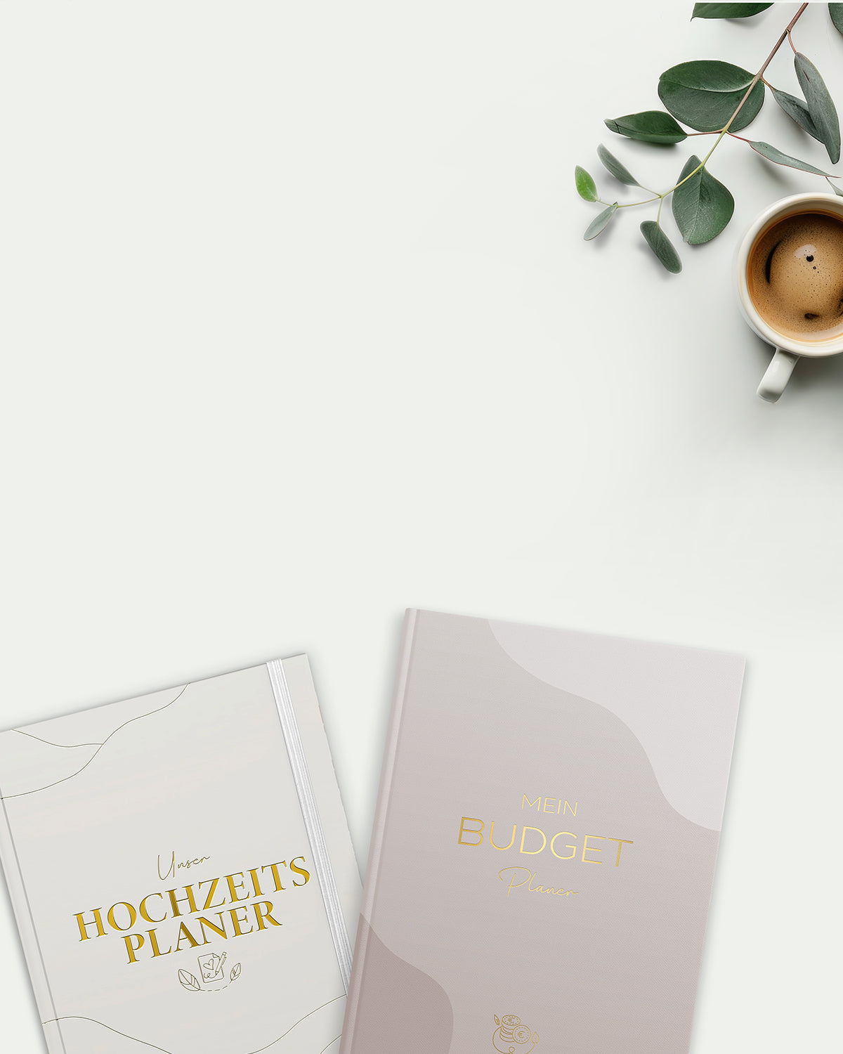 Hochzeitsplaner und Budget-Planer mit Goldschrift, Kaffee und Eukalyptuszweig auf weißem Tisch